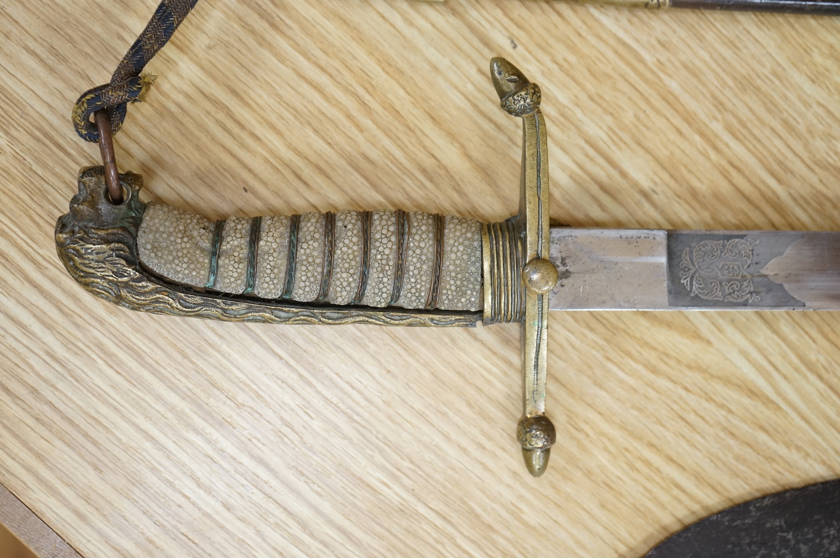 A post 1902 Naval Officer’s Dirk, the regulation blade with crowned fouled anchor, regulation hilt with remains of bullion dress knot in its leather scabbard with brass mounts, locket engraved with owners initials; RSA